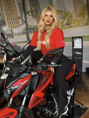 Promotora uniformizada apresentando uma motocicleta em ação de test ride