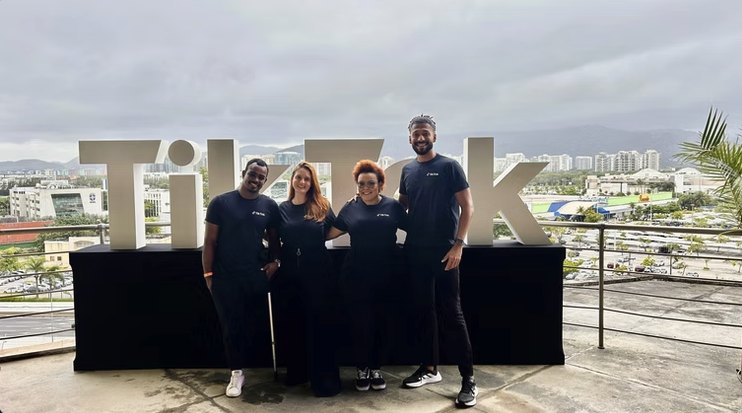 Equipe da Turbo em frente ao letreiro do TikTok em evento ao ar livre