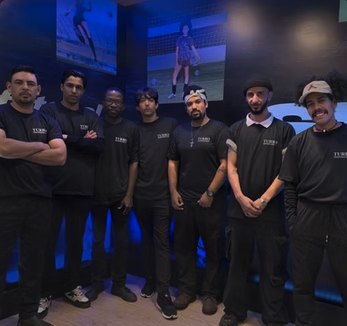 Equipe masculina da Turbo uniformizada de preto em evento corporativo noturno